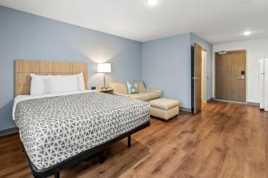 a bedroom with a bed and a living room at WoodSpring Suites Charlotte Northlake in Charlotte +16 photos