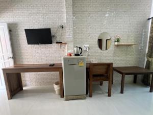 a kitchen with a refrigerator and a table and a tv at Rachawadee House Phang Nga in Phangnga +17 photos