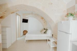 a white room with a white couch and a refrigerator at Palazzo Pezzolla Apartments in Monopoli