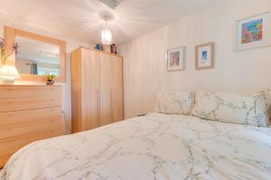 a bedroom with a bed and a wooden dresser at 2 Bed in Penzance oc-pc467 in Gulval +10 photos