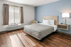a bedroom with a large bed and a window at WoodSpring Suites Charlotte Northlake in Charlotte