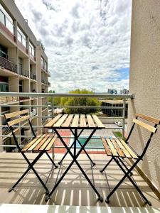 a picnic table and two chairs on a balcony at Madrid Modern Studio with Terrace & Parking in Madrid