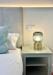 a bedside table with a lamp on it next to a bed at Madrid Modern Studio with Terrace & Parking in Madrid