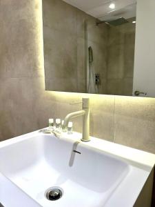 a white sink in a bathroom with a mirror at Madrid Modern Studio with Terrace & Parking in Madrid +11 photos