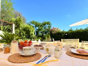 a table with cups and plates of food on it at Dimora Sorelle del Mar - Polignano a Mare in Polignano a Mare