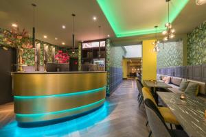 a bar in a restaurant with tables and chairs at Leonardo Hotel Antwerpen in Antwerp