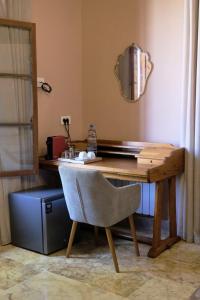 a wooden desk with a chair and a mirror at Spiritu in Ḩārat al Qal‘ah