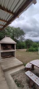 a shelter with a table and a picnic table at Cabaña Cecilia in Villa Icho Cruz