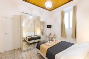 a hotel room with two beds and a mirror at Approdo Rooms - Eja Sardinia in Cagliari