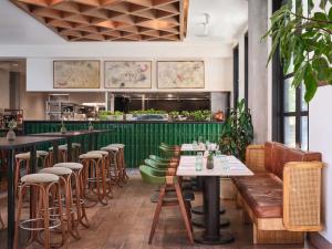 un ristorante con tavoli, sedie e un bar di Hotel Magdalena ad Austin