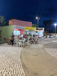 a man sitting at a table outside of a restaurant at Prado Hotel in Salgueiro