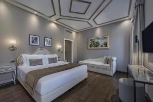 ein Schlafzimmer mit einem großen weißen Bett und einer Couch in der Unterkunft Hotel Olimpia Venice, BW Signature Collection 3sup in Venedig + 93 Fotos
