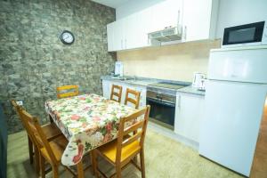 a kitchen with a table and chairs and a white refrigerator at Edificio Prieto VIV 2E in Puerto del Rosario