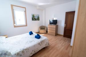 a bedroom with a bed and a tv and a chair at Edificio Prieto VIV 2E in Puerto del Rosario +37 photos