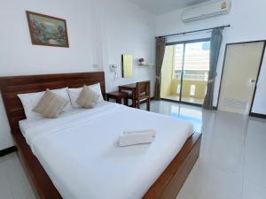 a bedroom with a white bed with a towel on it at Rachawadee House Phang Nga in Phangnga