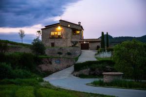 a stone house with a pathway in front of a building at Masia Lledó de Trascastell in Balsareny