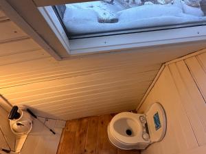 a small bathroom with a toilet and a window at Igloo-Dome by a River - Sky Sighting - Glamping in Litli-Árskógssandur +23 photos