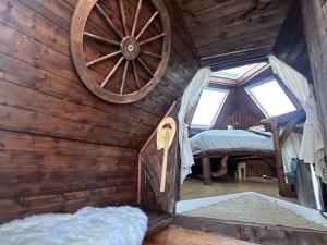 a room with a wooden wall with a large wooden wheel at Igloo-Dome by a River - Sky Sighting - Glamping in Litli-Árskógssandur