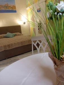 a bedroom with a bed and a table with a plant at NJ Stay Gozo in Għajnsielem