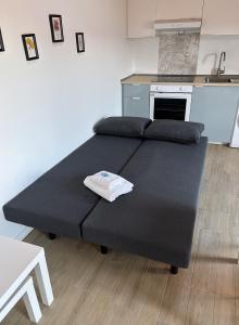 a large black bed in a room with a kitchen at Il Parco Apartment- Nature & Relax-Road To 5Terre in Beverino +26 photos