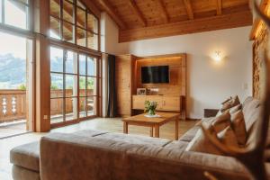 a living room with a couch and a tv at Berg- & Seeblick Pfefferbauer in Zell am See