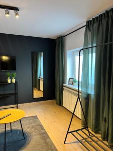 a living room with a table and a mirror at Różana City Apartaments in Kutno
