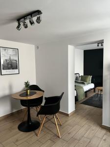 a living room with a table and a bed at Różana City Apartaments in Kutno