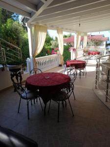 a patio with two tables and chairs on a porch at Hotel Gezimi in Shëngjin