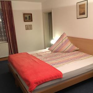 a bedroom with a bed with a red blanket on it at Wald Cafe in Simbach am Inn