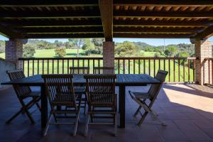 a black table and chairs on a porch with a deck at Masia Lledó de Trascastell in Balsareny