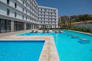 a swimming pool in front of a building at Occidental Tanger in Tangier