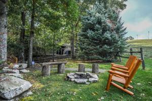 a wooden chair sitting in the grass near a fire pit at Alpine Adventure in McHenry