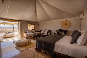 a bedroom with a bed in a tent at Oxygen Lodge Agafay in El Karia