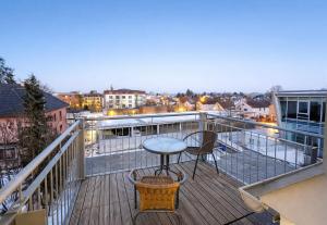 a balcony with a table and a view of a city at LETA Homes - Komfortable FeWo mit Traumbalkon mit flexiblem, Self-Check-In & eigenen Parkplätzen in Straubing