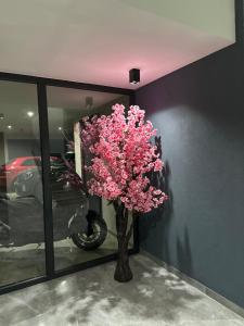a vase with pink flowers in a room at Project Georgiadi #1 - Modern Apartment in peaceful neighborhood - 15 mins from Loutra Pozar in Aridaia
