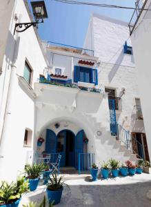 a white building with blue doors and potted plants at Janela Blue Civico 35 in Otranto