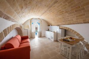 a living room with a red couch and a table at Janela Blue Civico 35 in Otranto