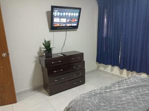 a bedroom with a dresser and a tv on the wall at Don Charlie in Veracruz