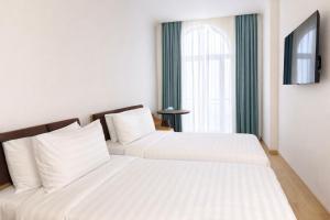 two beds in a hotel room with a window at Eighty Eight Deluxe Hotel & Spa in Tsaghkadzor