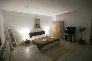a bedroom with a bed and a flat screen tv at Danser Residence Reșița in Reşiţa