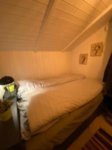 a small bed in a room with a ceiling at Huset ved stranden in Nykøbing Sjælland