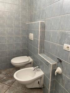 a bathroom with a toilet and a mirror at Appartamento sole in Vercana +37 photos