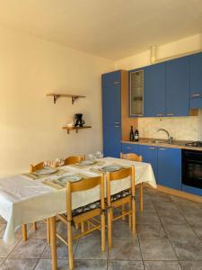 a kitchen with a table with chairs and blue cabinets at Appartamento sole in Vercana