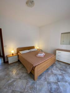 a bedroom with a bed with two lamps on it at Appartamento sole in Vercana