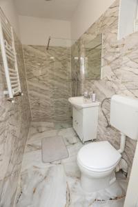 a bathroom with a white toilet and a sink at Danser Residence Reșița in Reşiţa
