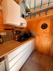 a kitchen with white cabinets and a sink at Tiny House na pevnosti Křelov in Olomouc +4 photos