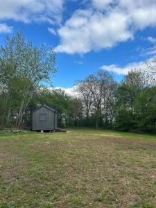 a small shed in a field with trees at Tiny House na pevnosti Křelov in Olomouc