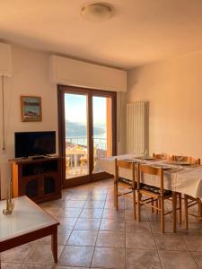 a living room with a dining table and a television at Appartamento sole in Vercana