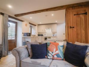 a living room with a couch and a kitchen at Rose Cottage in West Buckland