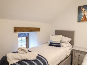 a small bedroom with a bed and a window at Rose Cottage in West Buckland